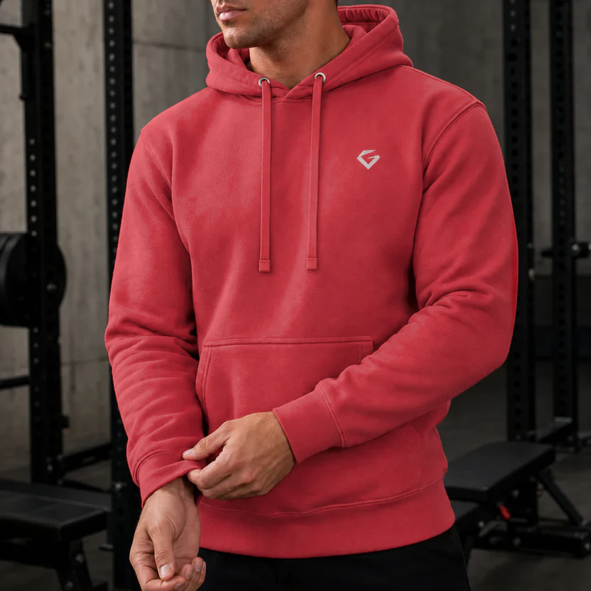 Team Red - Close view of a man wearing the Forge Hoodie with a small silver Gymstone logo in a gym.