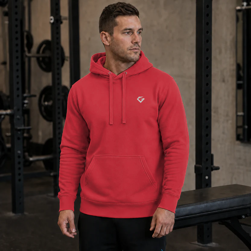 Team Red - A man in a gym wearing the Forge Hoodie with a small silver Gymstone logo, paired with black pants.
